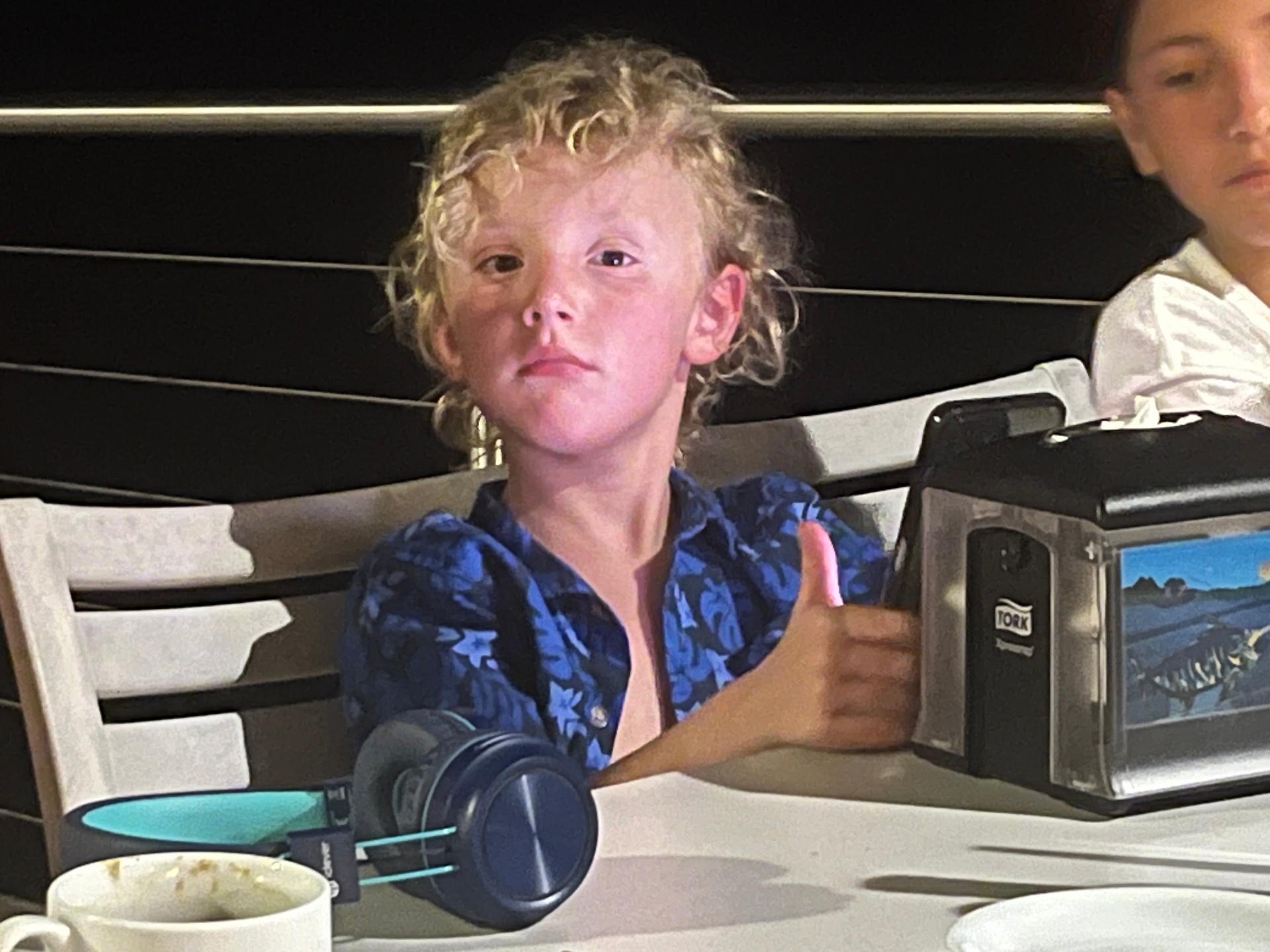 Logan giving a thumbs up at a restaurant